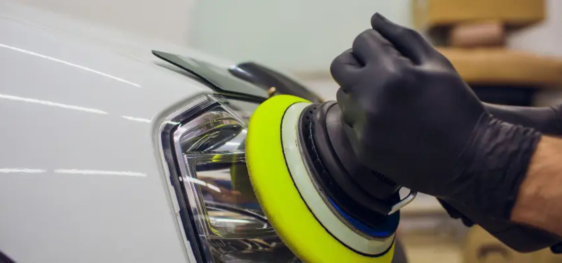 Technician working on vehicle headlight restoration